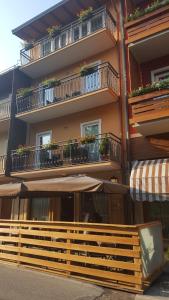 a building with balconies and a fence in front of it at La Locanda in Asiago
