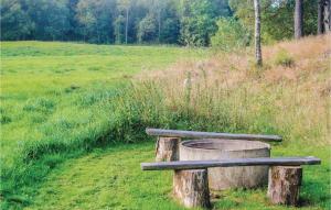 a bench sitting on a stump in a field at 2 Bedroom Awesome Home In Munka-Ljungby in Munka-Ljungby