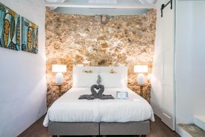 a bedroom with a white bed with two lamps at Sirena Bay Estate in Willemstad +60 photos
