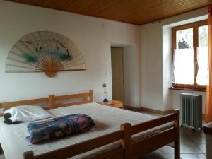 una camera con un grande letto con struttura in legno di Casa Hürlimann a Breno
