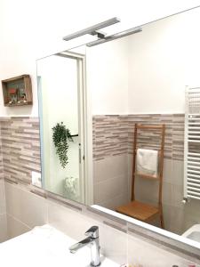 a bathroom with a large mirror over a sink at Mare&Sentieri Apartment in La Spezia
