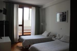 um quarto de hotel com duas camas e uma janela em Rêve D'Or na Póvoa do Varzim