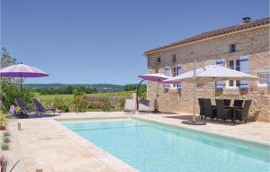 a pool with chairs and umbrellas next to a building at Awesome Home In Puy Levque With Private Swimming Pool, Can Be Inside Or Outside in Puy-lʼÉvêque