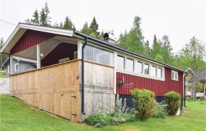 a large red house with a large wooden garage at Beautiful Home In Klssbol With 2 Bedrooms And Wifi in Prästhög