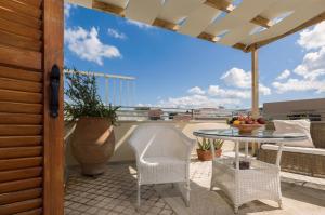 patio con mesa y sillas en el balcón en Avli Lounge Apartments en Rethymno Town