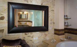
a mirror on a wall in a bathroom at Avli Lounge Apartments in Rethymno Town
