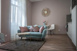 a living room with a blue couch and a table at MyApartment in the city center in České Budějovice