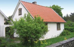 una antigua casa blanca con techo naranja en Lovely Home In Katthammarsvik With Kitchen en Katthammarsvik