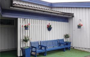 un banc bleu assis à côté d'un bâtiment avec des plantes en pot dans l'établissement Stunning Apartment In Agdenes With Kitchenette, à Selva