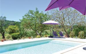 a purple umbrella and two chairs and a swimming pool at Cozy Home In Puy Levêque in Puy-lʼÉvêque