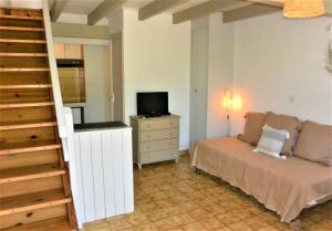 1 dormitorio con 1 cama, TV y escalera en CANELLA 2, en Favone