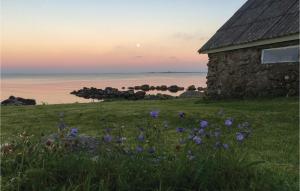 a field of purple flowers next to a stone building at Holiday Home Vanse Østhasselstrand Ii in Vanse +15 photos