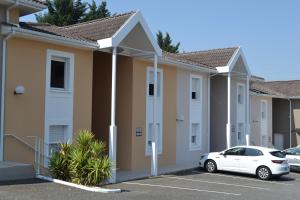 a row of houses with a car parked in a parking lot at Hôtel Formules Club 2 in Cenon +21 photos