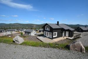 a house on a hill with rocks in front of it at Golfvegen 76 in Trysil