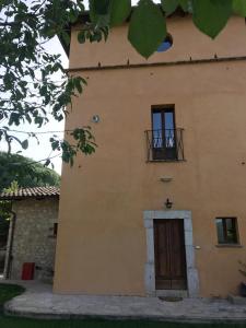 un edificio amarillo con una ventana y una puerta en La Colombaia, en Cascia