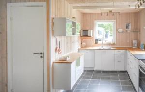 LidhultにあるStunning Home In Lidhult With Kitchenの黒いタイルフロアのキッチン(白いキャビネット付)