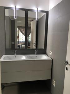 La salle de bains est pourvue de 2 lavabos et d'un grand miroir. dans l'établissement Kalendoola's Suite, à Lecce