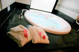 Water Hotel Mw (Love Hotel) في سايتاما: حمام مع حوض ومناشف على كاونتر