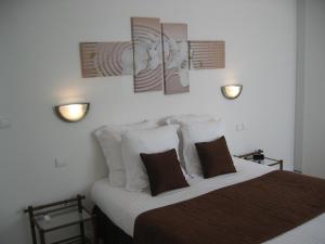 a bedroom with a bed and two lights on the wall at Résidence Le Beau Site in Capvern