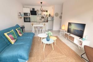 a living room with a blue couch and a table at Natsuocean in Vieux-Boucau-les-Bains