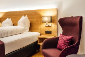 a hotel room with a bed and a chair at Hotel-Restaurant Bellevue in Flims +70 photos