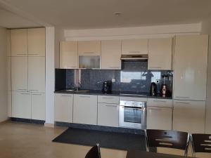a kitchen with white cabinets and silver appliances at Plage de rêve in Agadir nʼ Aït Sa