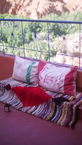 a bed with two pillows and a blanket on it at Monkey Fingers House by Fatima mellal in Tinerhir