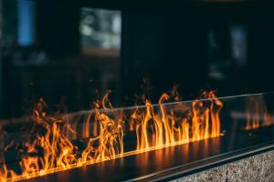 un feu brûle dans un foyer extérieur dans l'établissement Apart Lodge belMont, à Saas-Fee