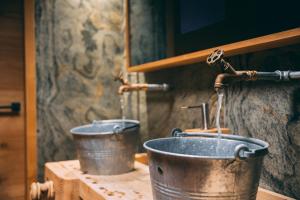 two buckets on a counter with a water fountain at Apart Lodge belMont in Saas-Fee