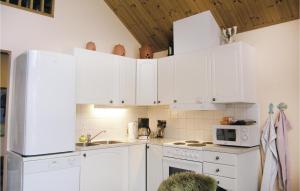 - une cuisine avec des appareils électroménagers et des armoires blanches dans l'établissement Awesome Home In Bolms With Ethernet Internet, à Bolmsö