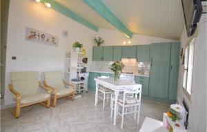 a kitchen with green cabinets and a table and chairs at 1 Bedroom Awesome Home In Visan in Visan