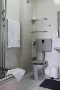 a bathroom with a toilet and a shower with towels at Rêve D'Or in Póvoa de Varzim