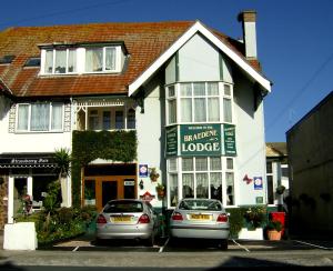 ein Haus mit zwei Autos, die davor geparkt sind in der Unterkunft Braedene Lodge in Paignton