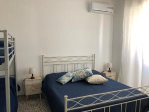 a bedroom with a bed with blue sheets and pillows at Residenza Marittima in Torre Canne +7 photos