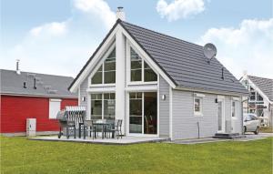 a house with a pitched roof with a table and chairs at 2 Bedroom Lovely Home In Zerpenschleuse in Zerpenschleuse