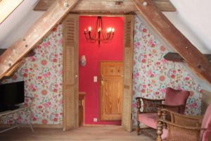 a living room with a red wall with flowers at Amberhoeve in Schorisse