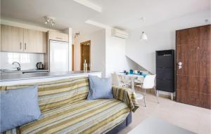 a living room with a couch and a kitchen at Cozy Apartment In Alhama De Murcia With Kitchenette in La Molata