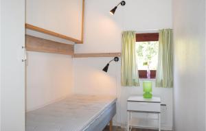 Habitación pequeña con cama y ventana en Klitterbyn 16, en Ängelholm