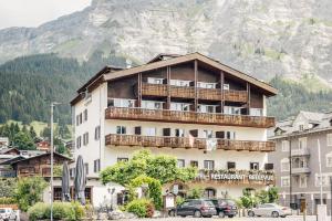 ein großes Gebäude vor einem Berg in der Unterkunft Hotel-Restaurant Bellevue in Flims