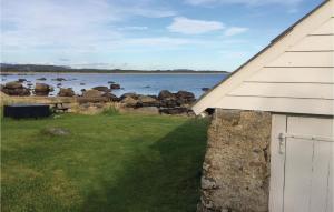 a barn with a view of a body of water at Holiday Home Vanse Østhasselstrand Ii in Vanse