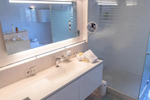 a white bathroom with a sink and a shower at Villa Sonne in Bodman-Ludwigshafen