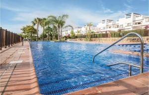 La MolataにあるStunning Apartment In Alhama De Murcia With 2 Bedrooms, Internet And Outdoor Swimming Poolの青い水とヤシの木が茂るスイミングプール