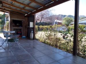 patio con mesa, sillas y vistas en Departamento Loma Hermosa en Santa Rosa de Calamuchita