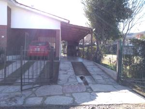 een garage met een auto geparkeerd onder een hek bij Departamento Loma Hermosa in Santa Rosa de Calamuchita