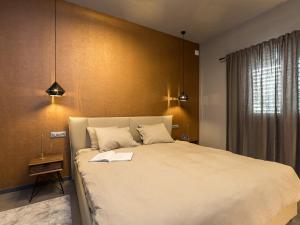 a bedroom with a large bed with a book on it at Magnolia - Modern Apartment near City Center and Sea in Poreč