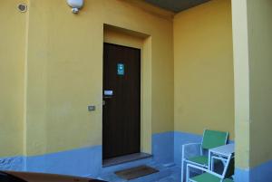 dwa krzesła siedzące przed drzwiami w budynku w obiekcie Bergamo Bassa w Bergamo