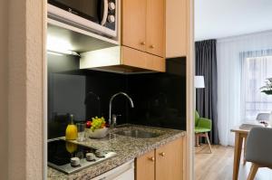 a kitchen with a sink and a dishwasher at Citadines Austerlitz Paris in Paris
