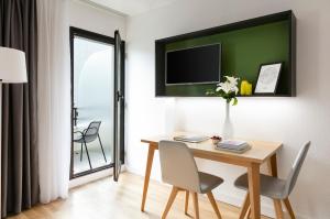 パリにあるシタディーン オステルリッツ パリのテーブルと椅子、壁にテレビが備わる客室です。