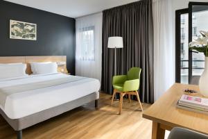 a bedroom with a bed and a desk and a chair at Citadines Austerlitz Paris in Paris