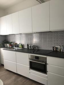 uma cozinha com armários brancos e um forno com placa de fogão em dimora scaldaferro em Mira